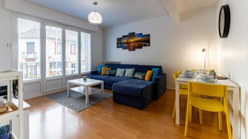 un salon avec un canapé bleu et une table dans l'établissement Le Wilson appart, à Dijon