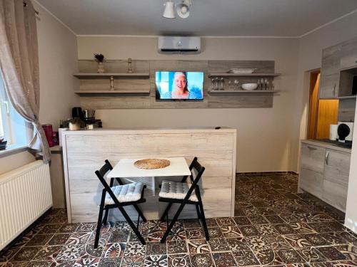 une cuisine avec une table et deux chaises et une télévision dans l'établissement CentralPark Suites, à Maribor