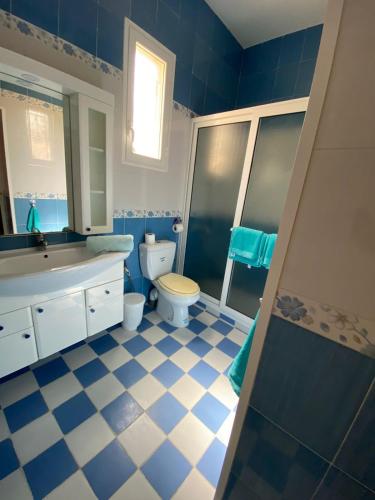 a blue and white bathroom with a toilet and a sink at Dar Rita in Houmt Souk