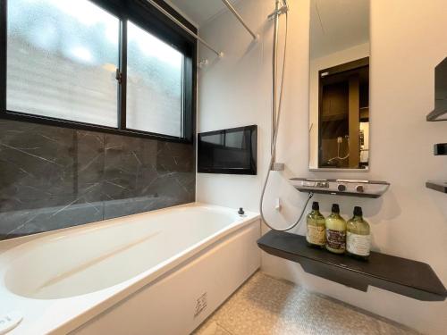 a bathroom with a tub and a sink and a window at New三軒茶屋ハウス 渋谷まで電車5分 三軒茶屋駅徒歩6分 2023年フルリノベ戸建 in Tokyo