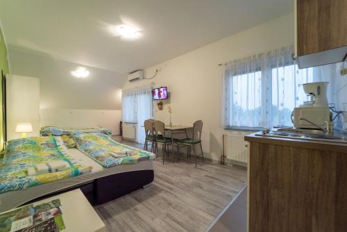 a room with a bed and a kitchen with a table at Studio Apartments Ante in Rakovica