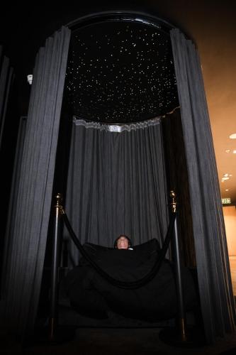 a man sitting in a hammock in front of a curtain at The Capital 15 on Orange Hotel & Spa in Cape Town