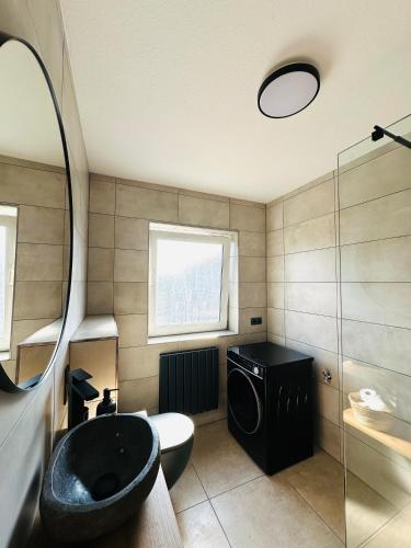 a bathroom with a black tub and a sink at Casa del Sol - Ferienwohnung Norddeich in Norddeich