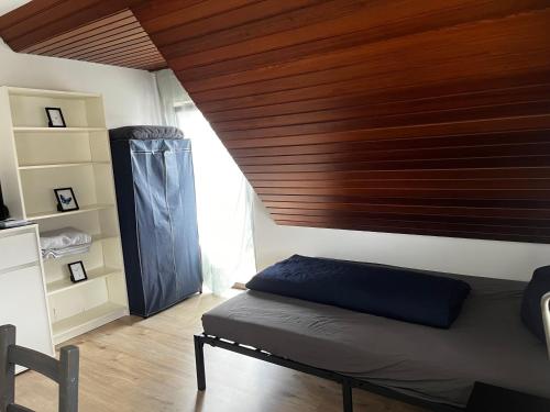 a bedroom with a bed and a wooden ceiling at Gemütliches Gästezimmer im Casa Kirchweg in Gladbach
