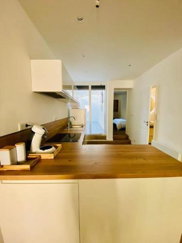 a kitchen with white cabinets and a wooden floor at Maison à Cholet in Cholet