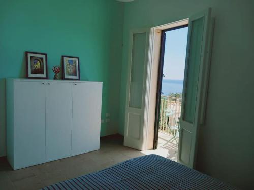 a room with a door open to a balcony at Casa Vacanza fronte mare Il Rifugio di Alice in Andrano