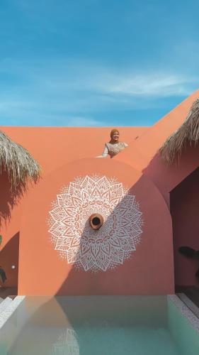 a man sitting on a building with a mandala on it at Villa Namastay by Suasana Villa in Cepit