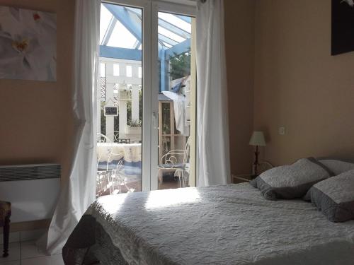 a bedroom with a bed and a sliding glass door at Chambre Privée Chez l'Habitant in Capbreton