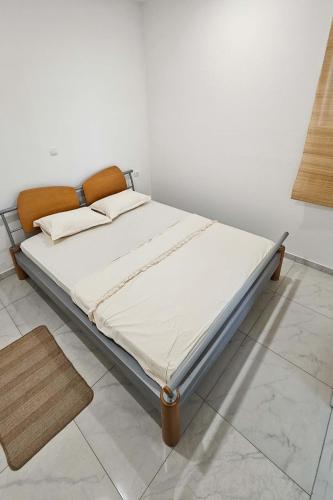 a bed in a room with a white wall at Dora in Posušje