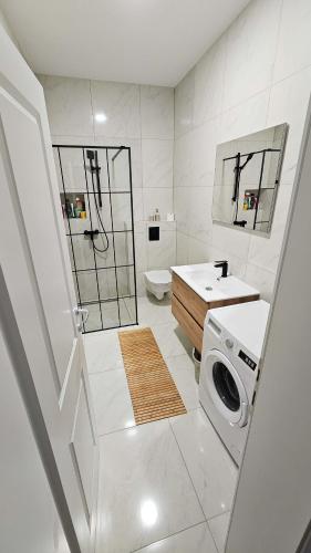 a white bathroom with a sink and a washing machine at Dora in Posušje