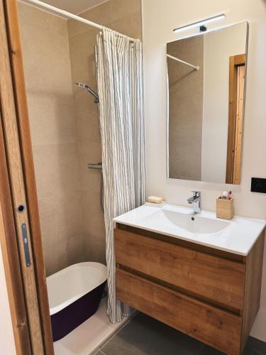 une salle de bain avec un lavabo, une baignoire et un miroir dans l'établissement L'Olympe de Combloux - Terrasse & balcon sur la forêt, à Combloux