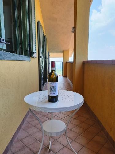 a bottle of wine sitting on a white table at Soggiorno con splendida vista in Monforte dʼAlba