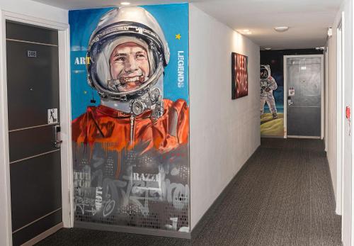 a hallway with a painting of an astronaut on the wall at Rise Urban Art Hotel in Larnaka