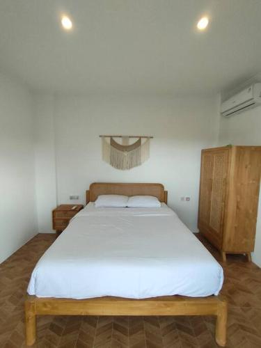 a bedroom with a large bed with white sheets at FREE airport pickup for new 2BR villa near Canggu in Sangeh
