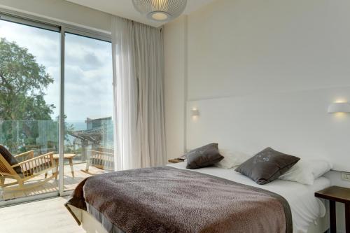 a bedroom with a bed and a large window at Residence Beach Hotel in Netanya