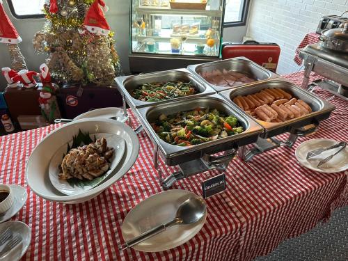 a table topped with trays of food on a table at The Terminal Khon Kaen Hotel in Khon Kaen