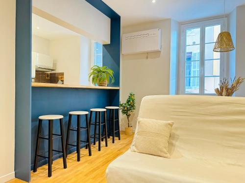 Cette chambre comprend un lit et quelques tabourets de bar. dans l'établissement L'écrin - 2 pièces - Le Suquet, à Cannes