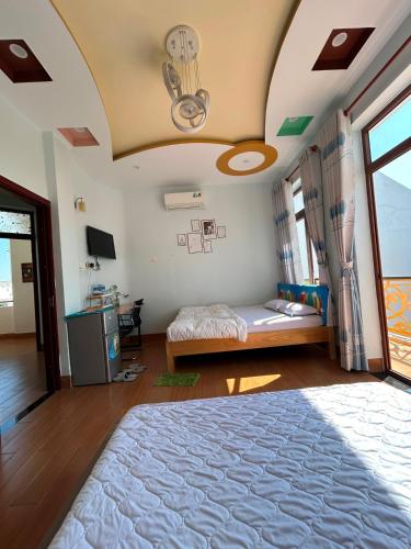 a bedroom with a large bed and a ceiling at Lộc Vừng Homestay in Phan Thiet