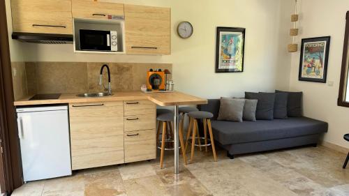 a kitchen with a couch and a table in a room at HomeStay Bormes in Bormes-les-Mimosas