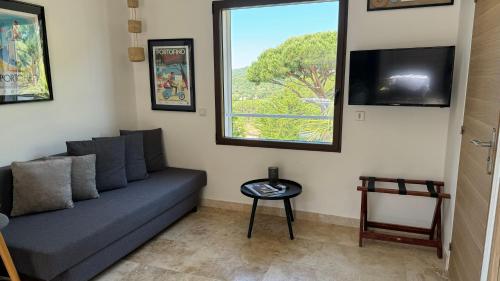 a living room with a couch and a window at HomeStay Bormes in Bormes-les-Mimosas