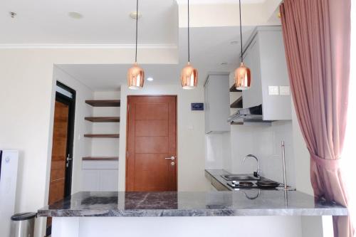 a kitchen with a marble counter top and pendant lights at Spacious 3BR at Gateway Pasteur Apartment By Travelio in Bandung