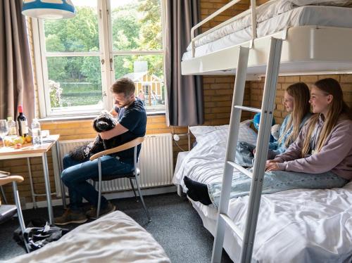 a group of people sitting in a dorm room with bunk beds at Danhostel Silkeborg in Silkeborg