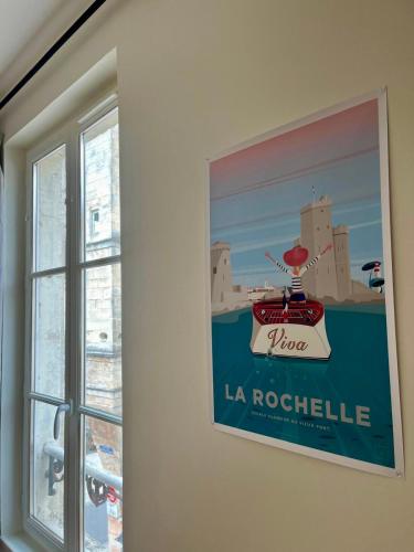 une photo d'un bateau sur un mur à côté d'une fenêtre dans l'établissement Appartement 1 chambre près du Marché, à La Rochelle