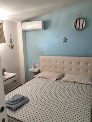 a bedroom with a bed and a blue wall at Affittacamere Dolci Notti in Budoni