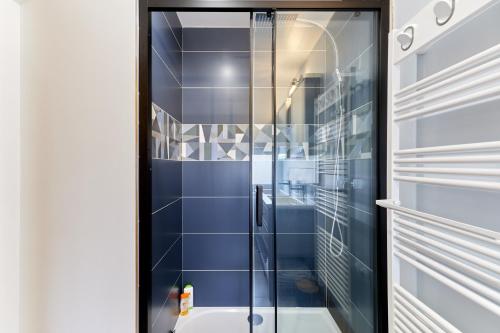 a bathroom with a shower with blue tiles at Le refuge des hiboux - Charmante maison pour 6p in Saint-Pierre-sur-Dives