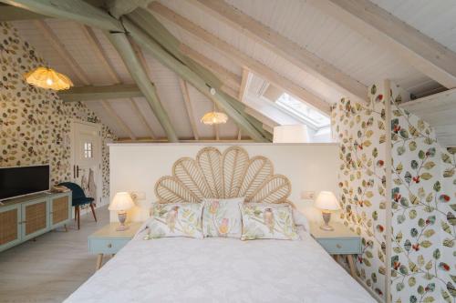 1 dormitorio con 1 cama, 2 lámparas y TV en Apartamentos Boutique Casa Cigarrán, en Vegadeo