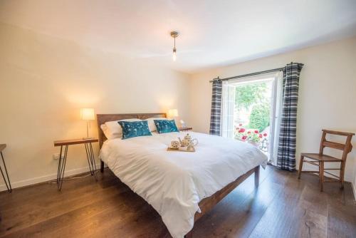 een slaapkamer met een groot bed en een raam bij Olive Cottage, Wickham Market in Wickham Market