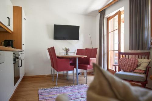 a living room with a table and red chairs at Haus Altana in Gargellen