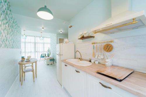 una cocina con fregadero y refrigerador en Apartamentos Boutique Casa Cigarrán, en Vegadeo