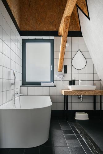 a white bathroom with a tub and a sink at Willa Czaremka - sauna, basen, kino, bilard, bawialnia in Ujsoły