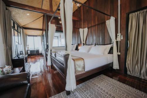 a bedroom with a large bed with wooden walls at Mont De Pua in Amphoe Pua