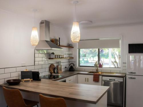 a kitchen with a wooden counter top and two lights at Buchan Motel in Buchan