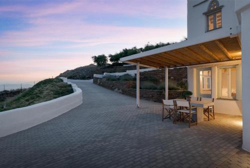a patio of a house with a table and chairs at Morfes Luxury Apartments in Triandáros