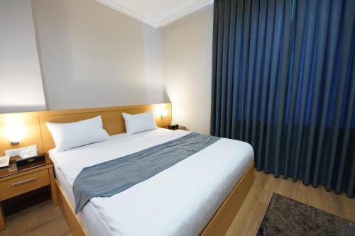 Una cama o camas en una habitación de Yarmouk Hotel Erbil