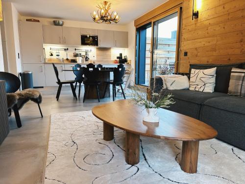 un salon avec un canapé et une table dans l'établissement L'Olympe de Combloux - Terrasse & balcon sur la forêt, à Combloux