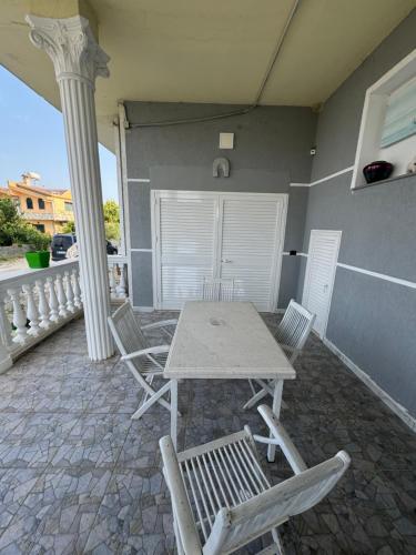a table and chairs on the porch of a house at Vacation Apartments in Hamallaj in Armath