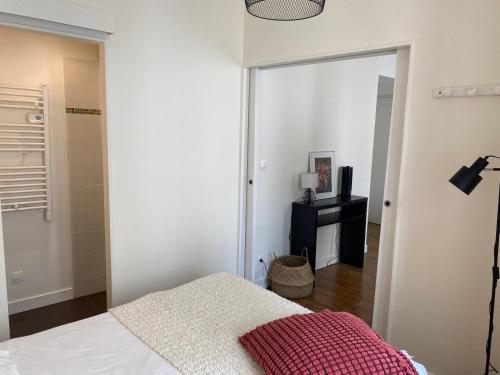 une chambre avec un lit avec une couverture rouge dans l'établissement Appartement 1 chambre près du Marché, à La Rochelle