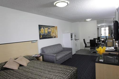 a hotel room with a bed and a chair and a desk at Comfort Inn & Suites Goodearth Perth in Perth