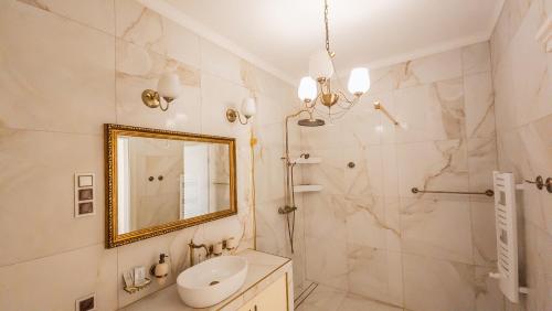ein weißes Badezimmer mit einem Spiegel und einem Waschbecken in der Unterkunft Restauracja & Pokoje Gościnne Polowczyk in Miąskowo