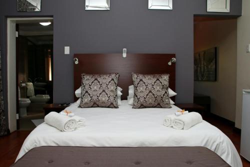 Säng eller sängar i ett rum på Aalwyns Guesthouse
