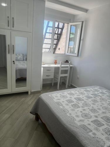 a bedroom with a bed and a desk and windows at Vue sur Mer 6 personnes - Location Azeffoun Ait Chafaa-8300Da in Aït Chafa