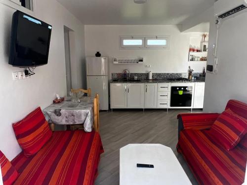 a living room with two couches and a kitchen at Vue sur Mer 6 personnes - Location Azeffoun Ait Chafaa-8300Da in Aït Chafa