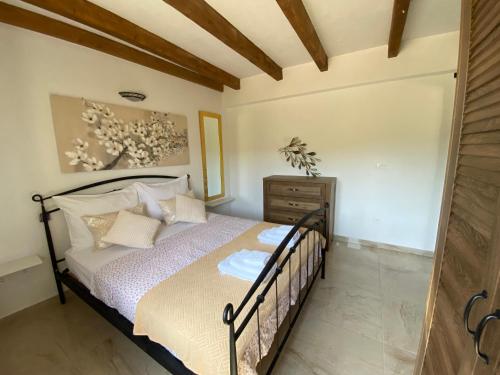a bedroom with a bed and a wooden ceiling at Vikendica Oliver in Medovdolac