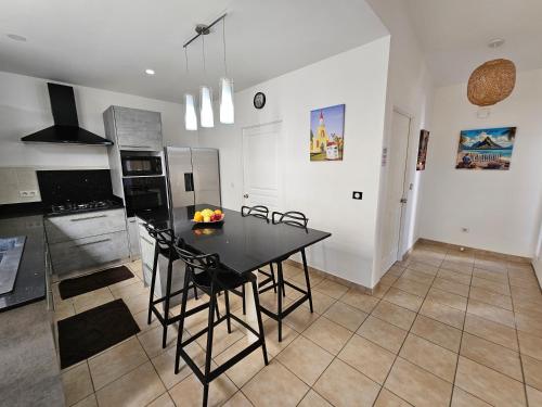 a kitchen with a black table and chairs in it at Cozy House in a private complex in Paea