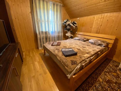 a bedroom with a bed with a dog laying on it at Malinada-kaimo sodyba in Šalčininkai