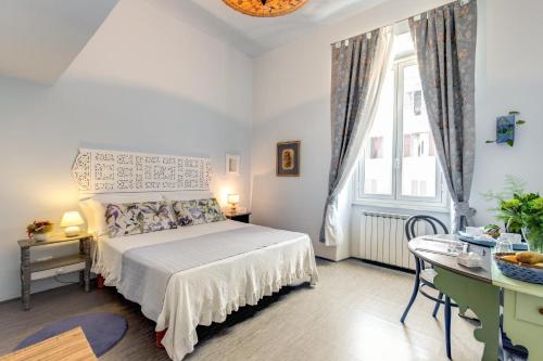 sypialnia z łóżkiem, biurkiem i oknem w obiekcie La Casa Di Amy w Rzymie